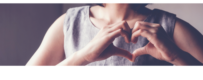 woman making a heart symbol with her hands